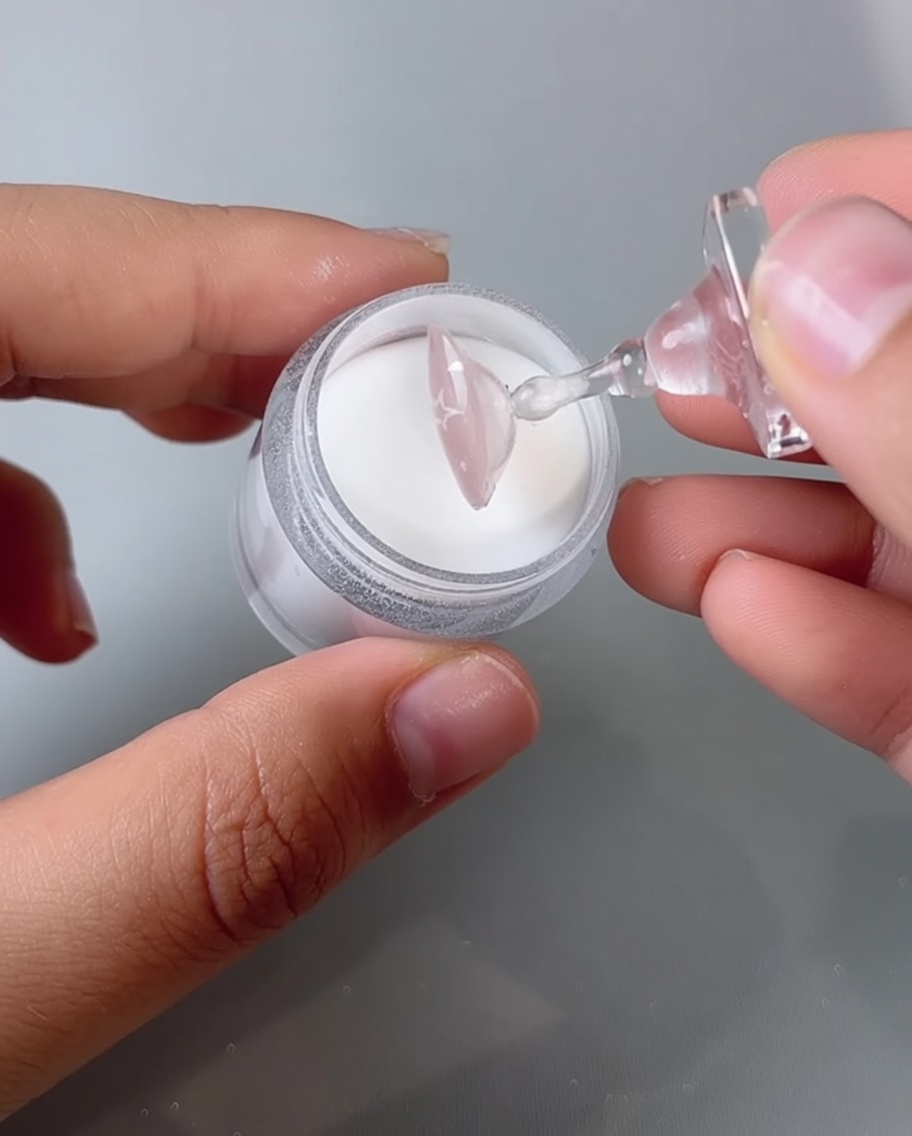 Ongle placé sous une lampe UV/LED pour la catalyse.