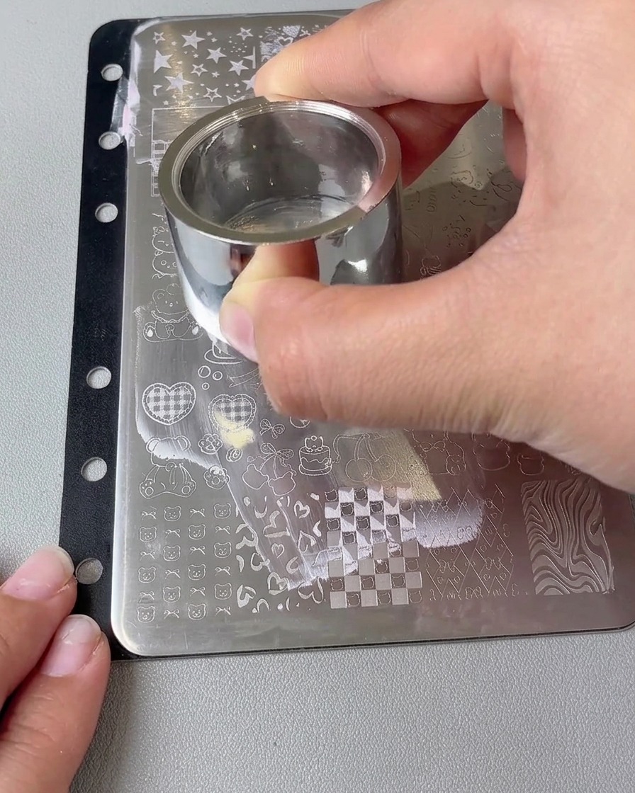 Gros plan dun grand tampon transférant un motif de cœur sur un ongle.