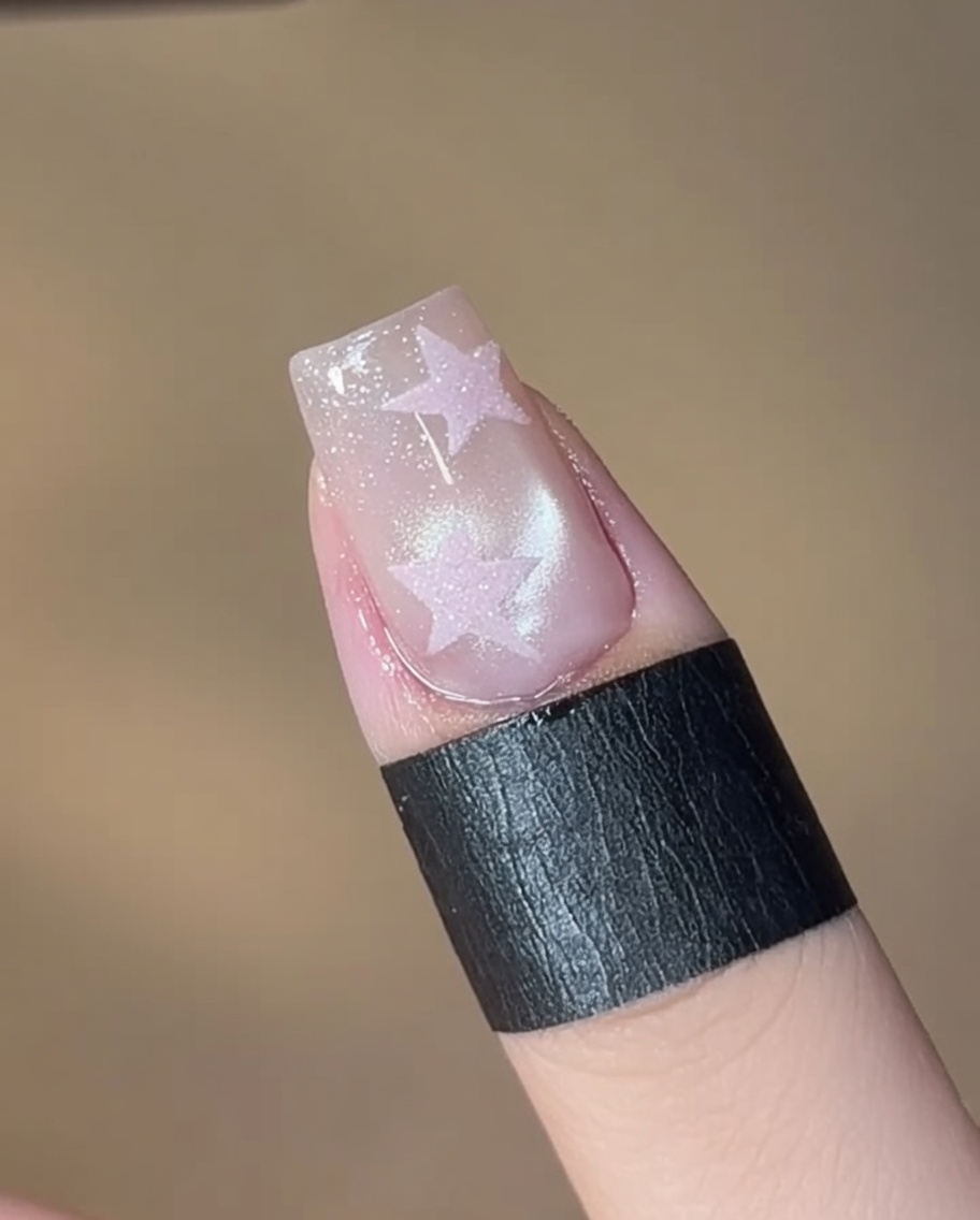 Un pinceau appliquant un gel cat-eye scintillant numéro 05 sur une plaque dongle propre.
