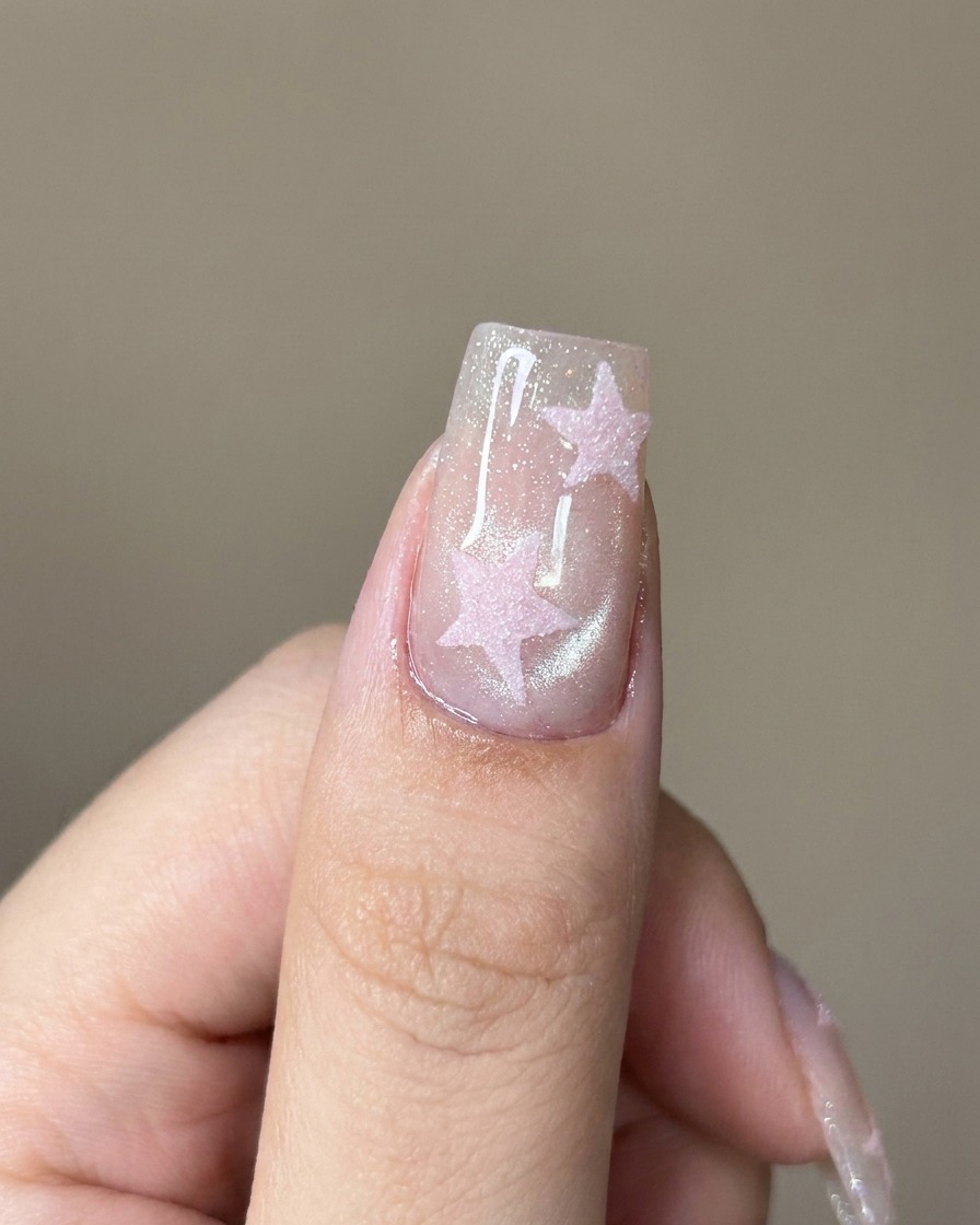 Un pinceau appliquant un top coat transparent sur longle cat-eye brillant.