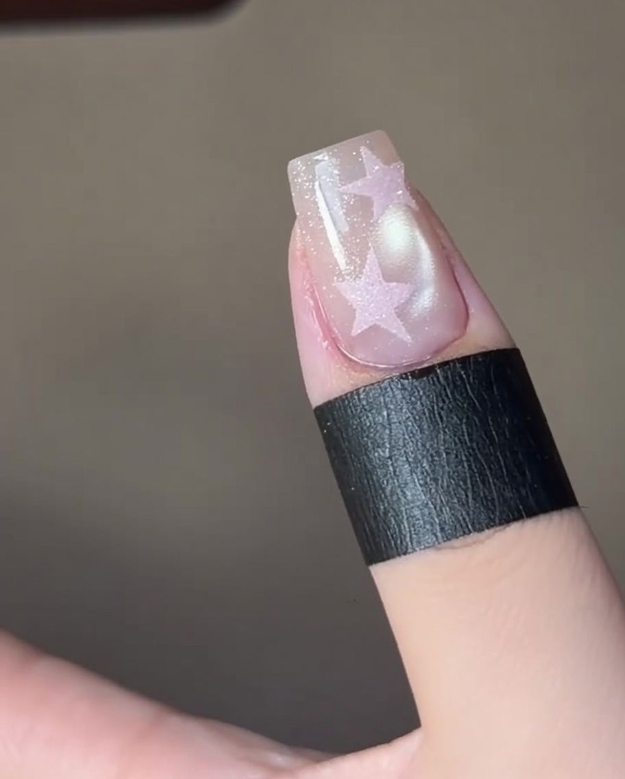 Doigts catalysant un design détoile sous une lampe UV professionnelle.