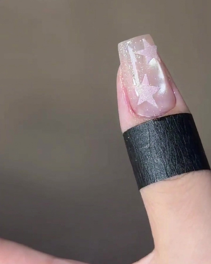 Un sticker en forme détoile placé sur le bout dun ongle.