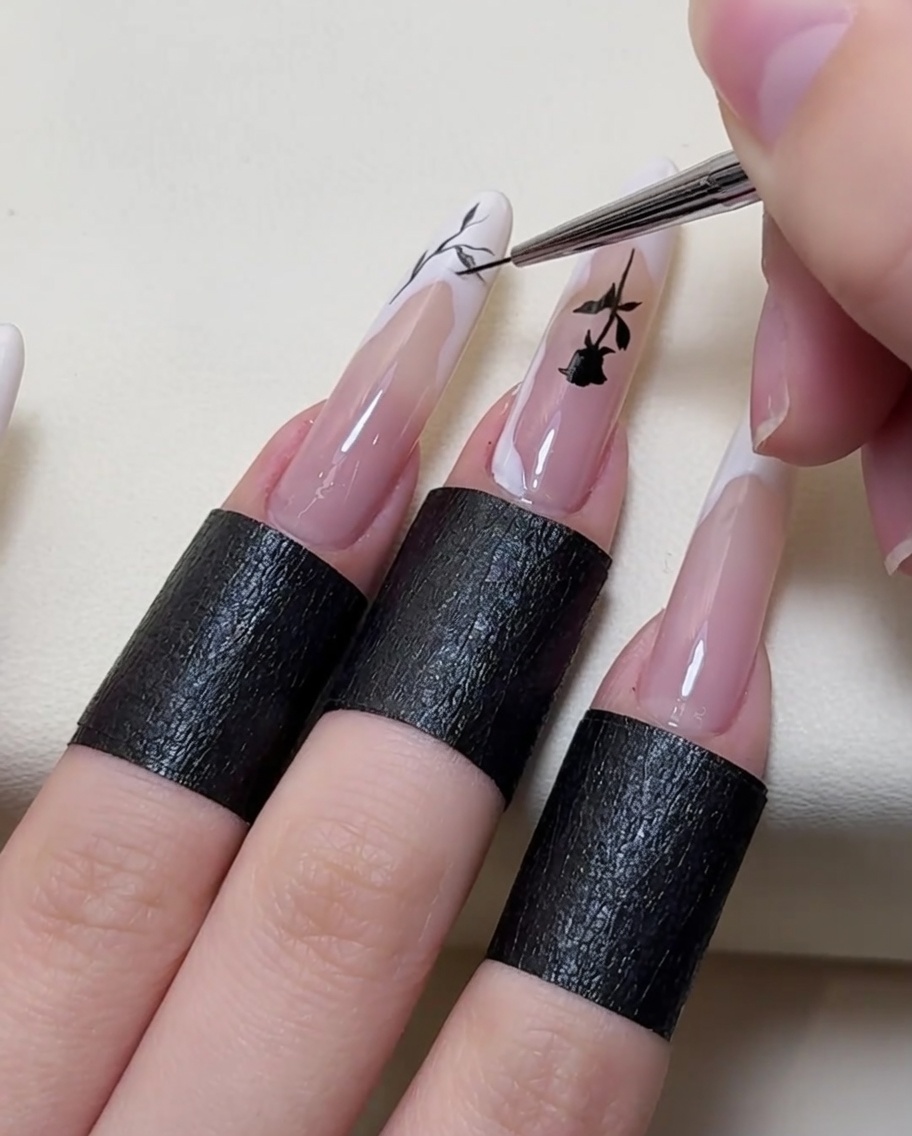 Gros plan sur un pinceau ajoutant des détails complexes de branches sur le nail art.