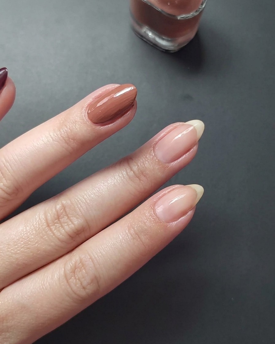 Gros plan montrant lapplication dun vernis mauve sur longle du majeur.