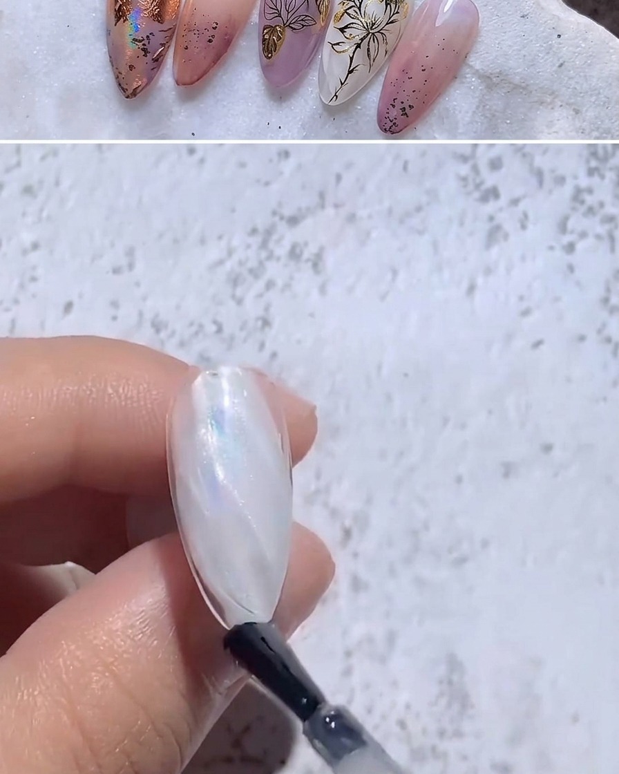 Un pinceau appliquant un top coat brillant transparent sur un ongle aux reflets iridescents.