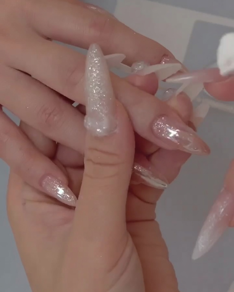 Gros plan montrant un pinceau appliquant une couche de base gel translucide de type jelly sur un ongle naturel.
