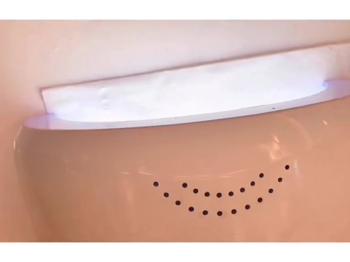 Une main placée dans une lampe LED allumée, en train de catalyser la base coat.