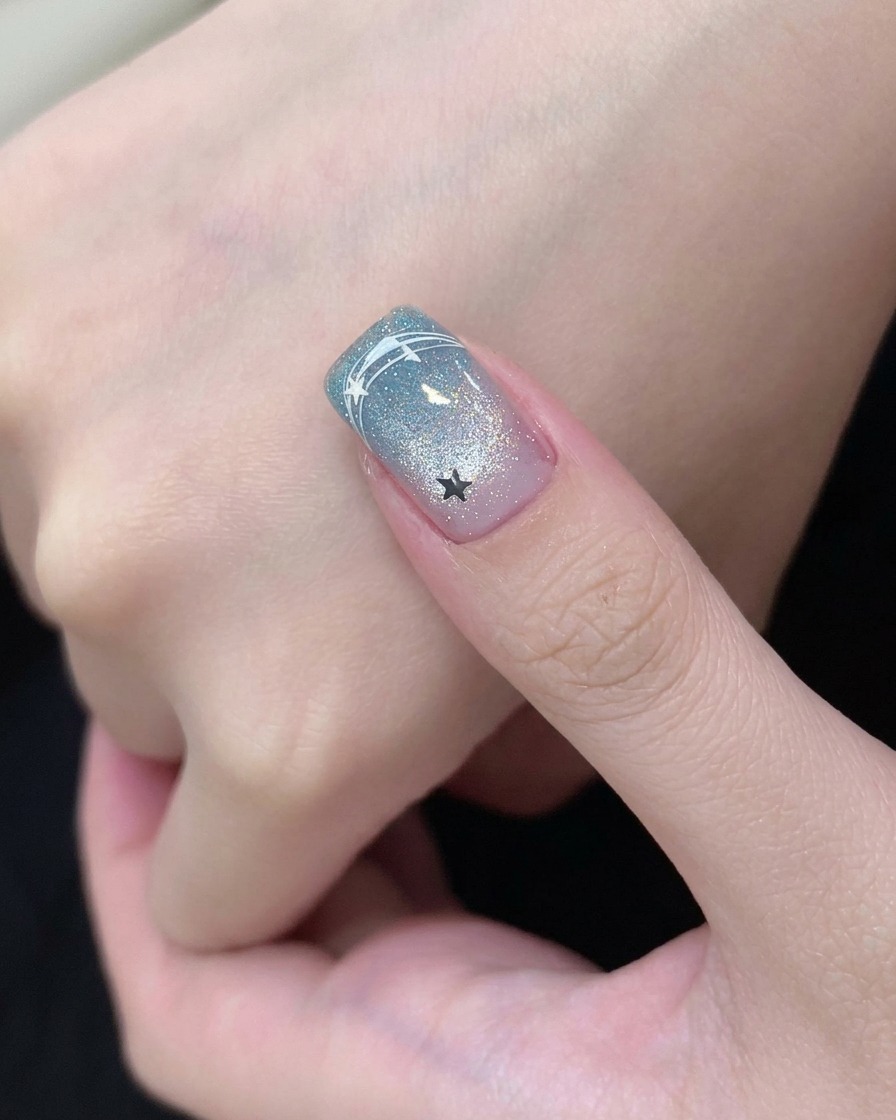 Un pinceau appliquant une base coat transparente sur un ongle préparé.