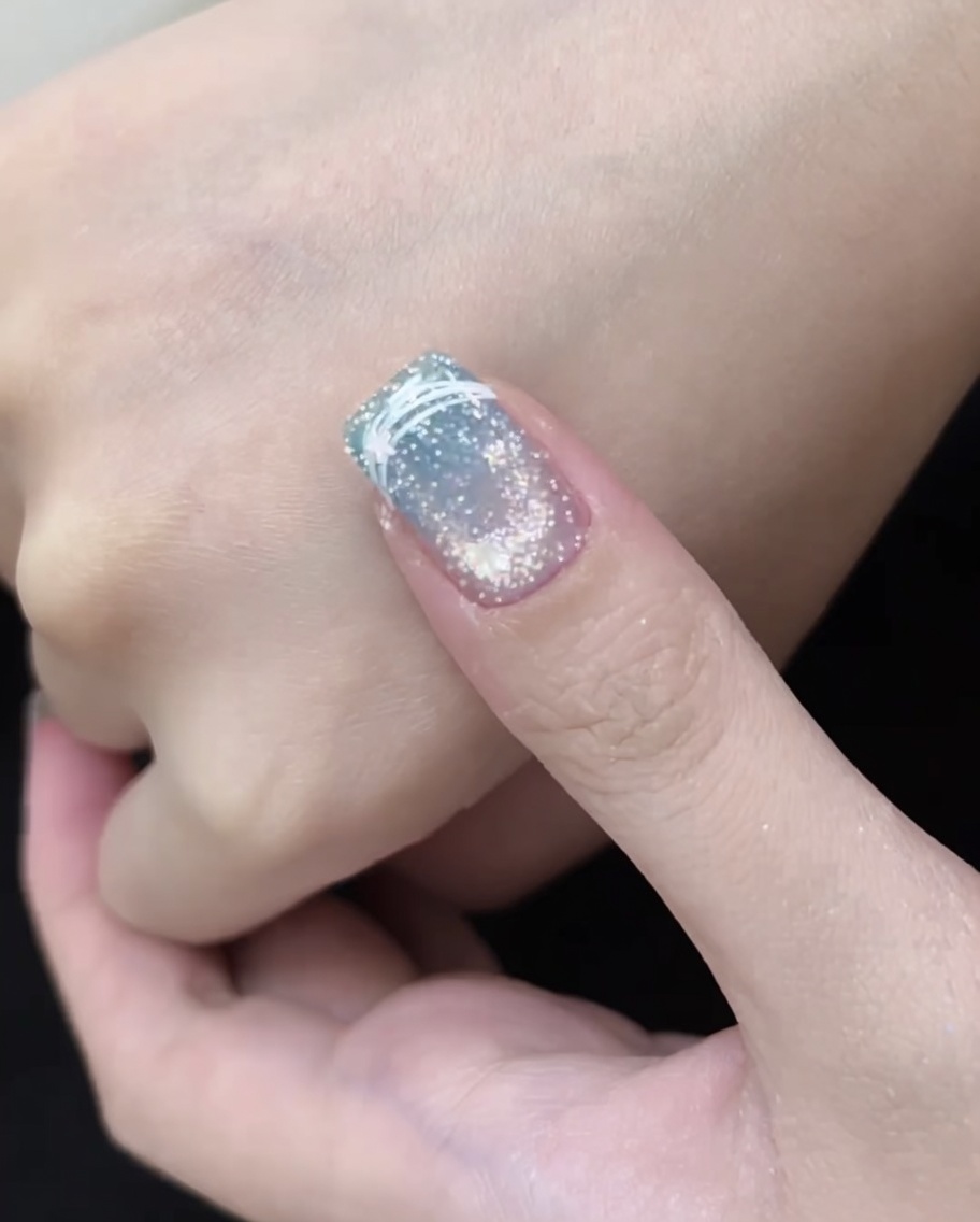 Un ongle placé sous une lampe LED rouge, montrant le processus de catalyse.