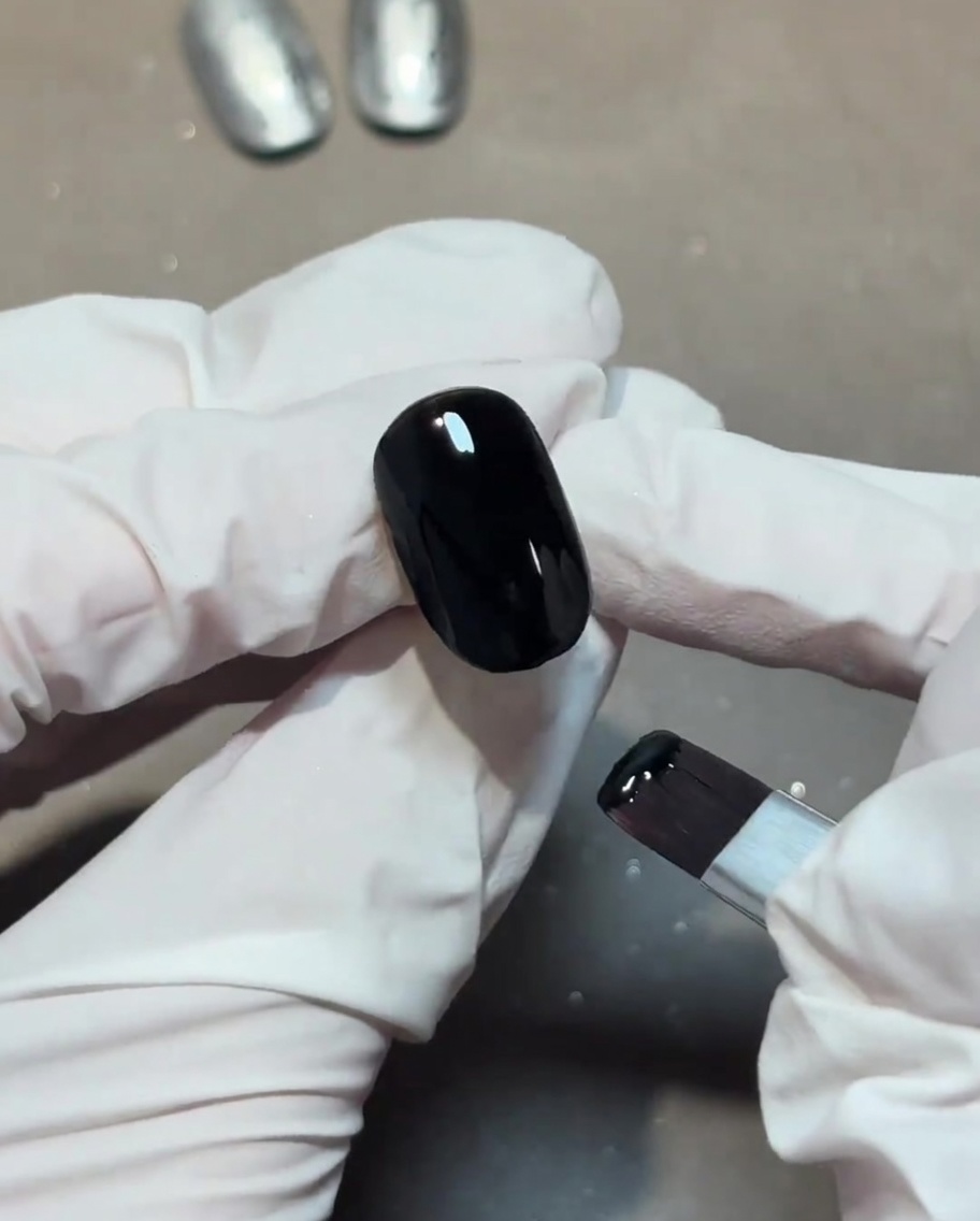 Application dun top coat brillant transparent sur une base dongle noire.