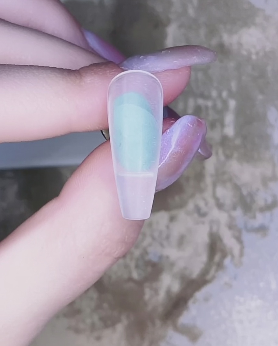 Gros plan dun pinceau appliquant un vernis gel rose translucide sur la surface dun ongle naturel.
