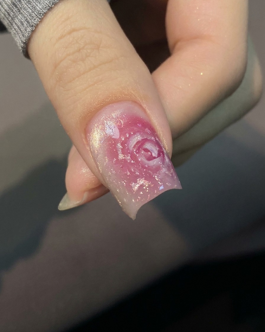 Gros plan dun pinceau appliquant une base transparente sur un ongle naturel.