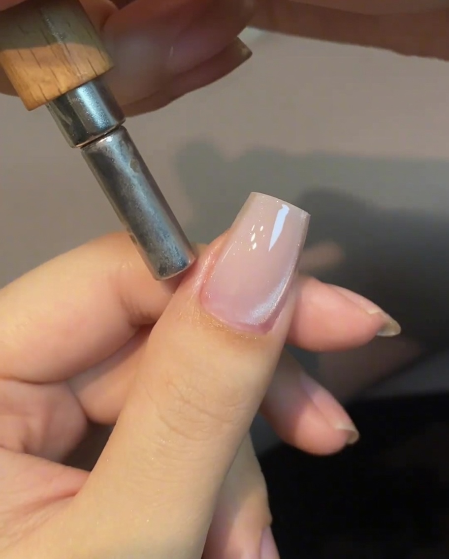 Un aimant cylindrique placé près du côté de longle pour manipuler les reflets.