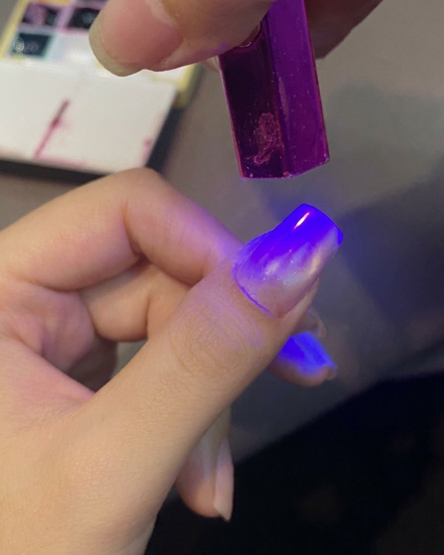 Un ongle catalysé sous une mini lampe UV pour fixer le motif.