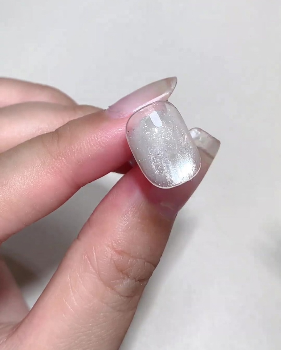Du liquide blooming coloré déposé sur un ongle avec du blooming gel humide pour former des bulles.
