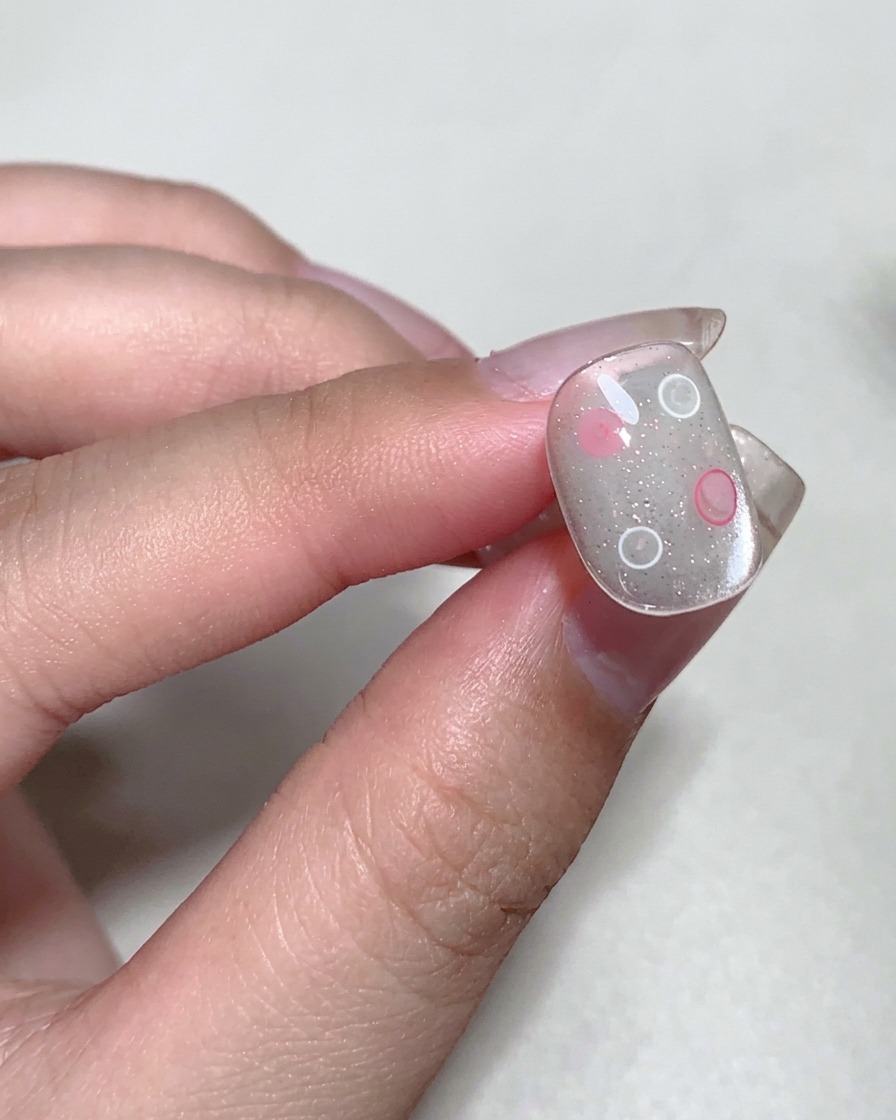 Gros plan sur un ongle en train de catalyser sous une lampe professionnelle pour ongles UV.