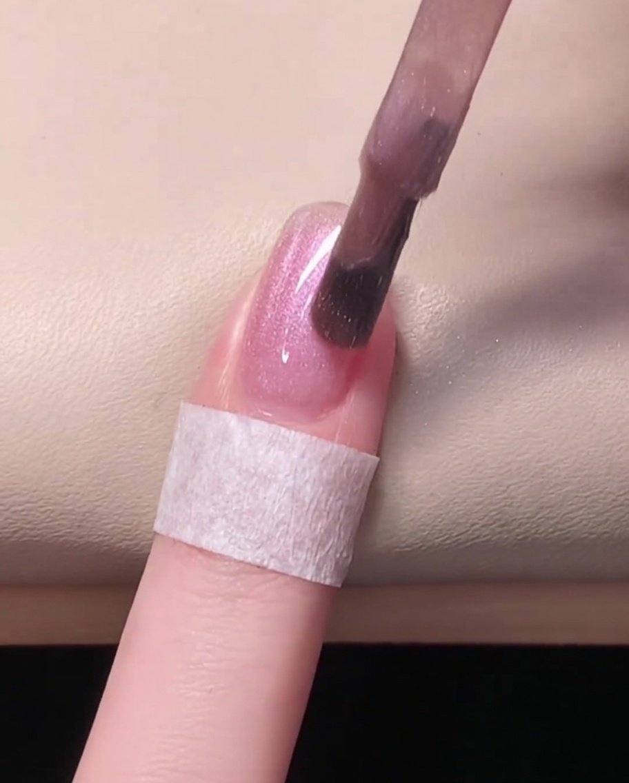 Un ongle illuminé à lintérieur dune lampe UV/LED pendant le catalysage.