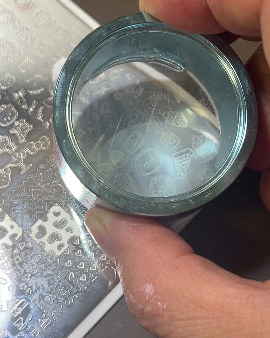Un tampon en silicone transparent pressé sur la plaque pour transférer le motif.