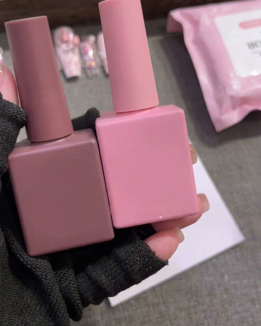 Gros plan montrant une goutte de vernis gel marron sur du papier palette blanc.