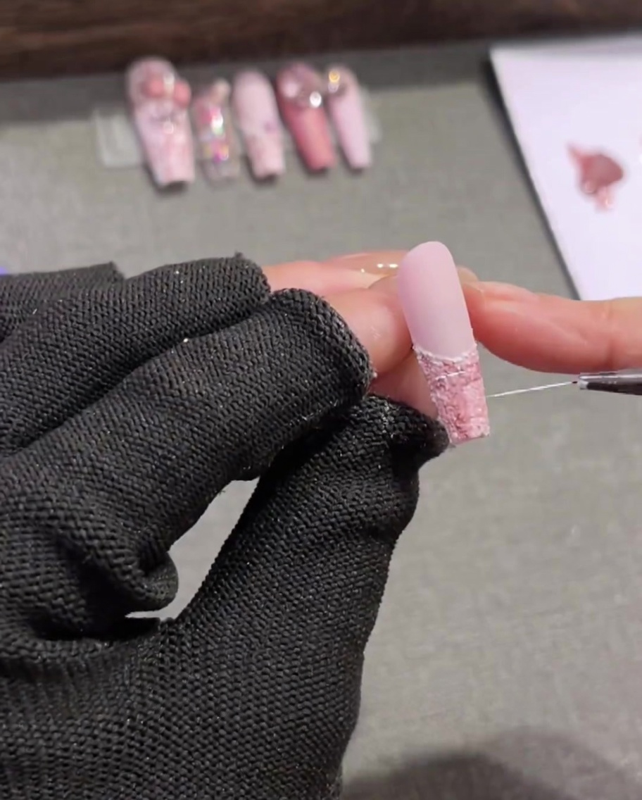 Un très fin et long pinceau liner balayant de délicates lignes blanches aléatoires à travers un design dongle en tweed rose et marron.