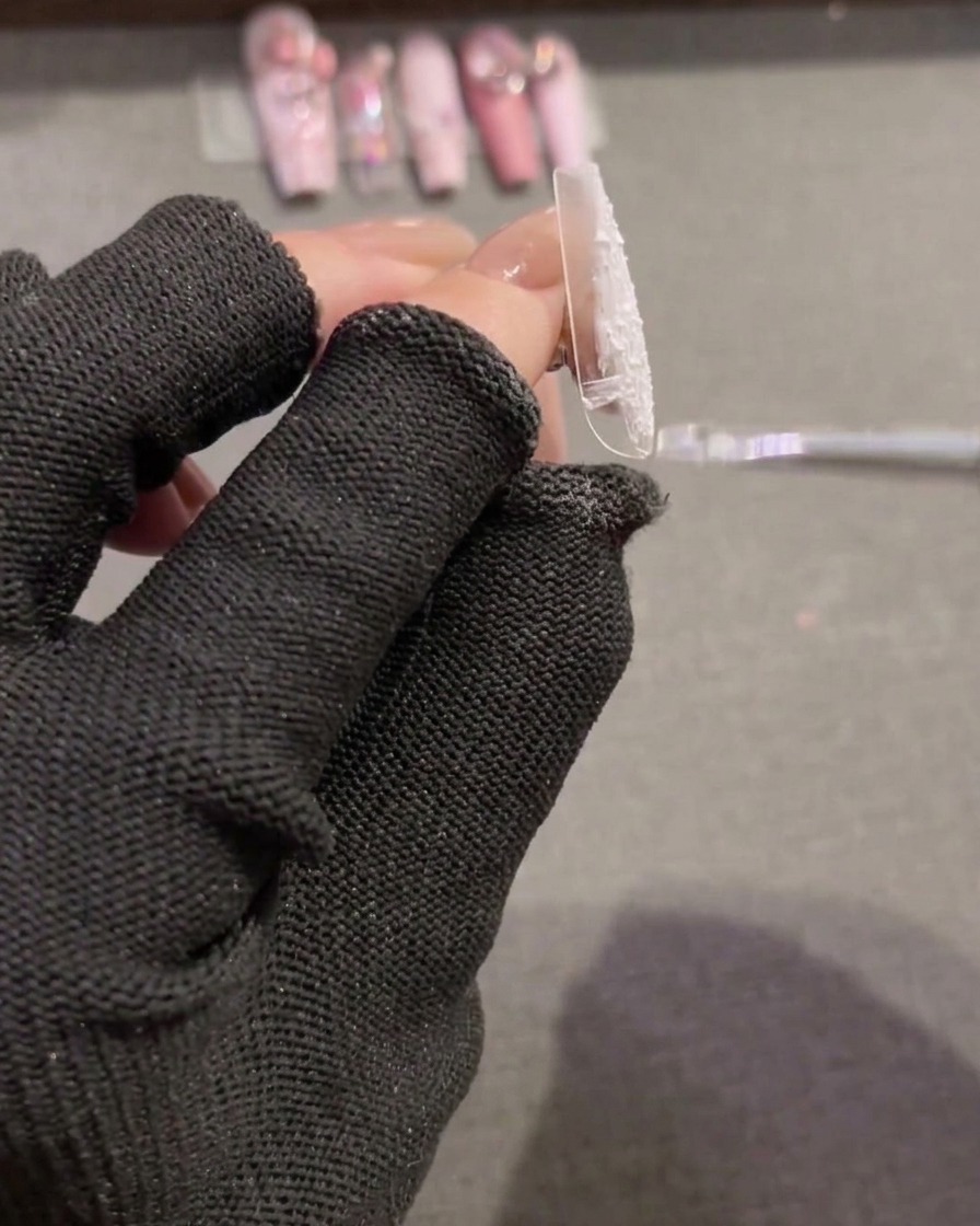 Un pinceau étalant du gel plaster blanc texturé sur une nouvelle capsule transparente pour créer une base couvrante.