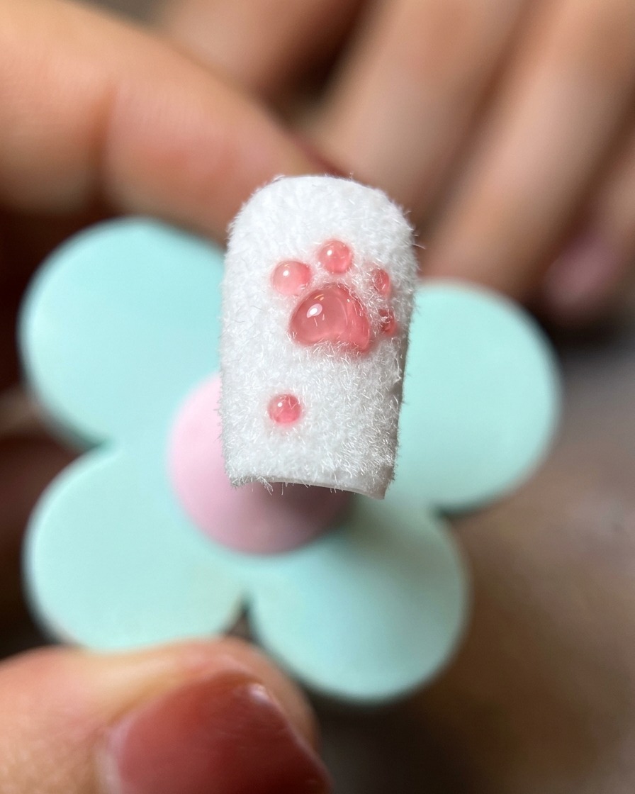 Gros plan dun design de patte de chat fini, avec lexcès de poudre de flocking retiré par une brosse à poils souples.