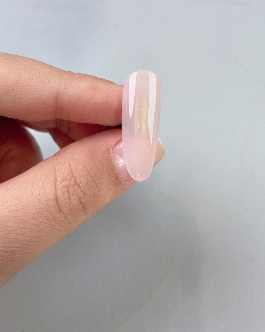 Une base en gel jade transparente et légèrement laiteuse appliquée sur un ongle naturel.