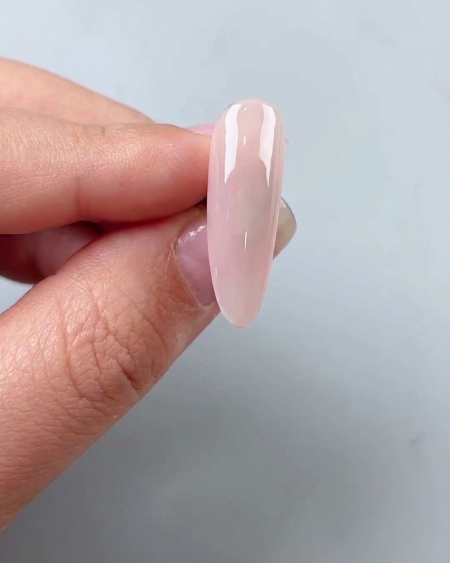 De petits flocons de feuille dor placés sur la surface dun ongle avec une pince à épiler.