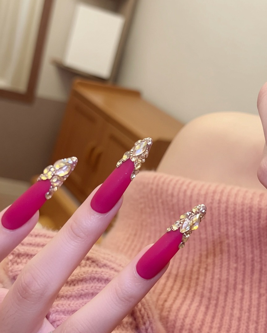 Angle rapproché des ongles focalisé sur les clusters de cristaux étincelants posés sur la base rose mate.