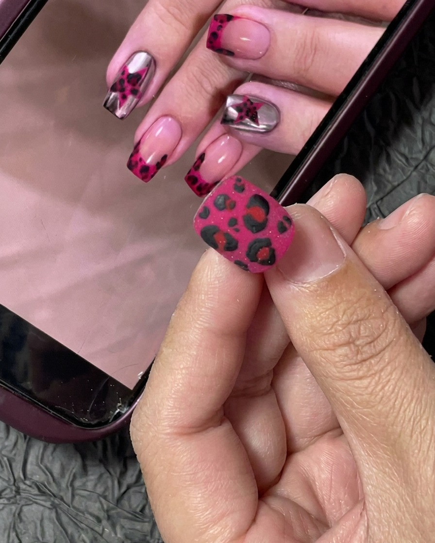Un embout dongle recouvert de vernis gel rose néon vibrant à laide dun pinceau professionnel.