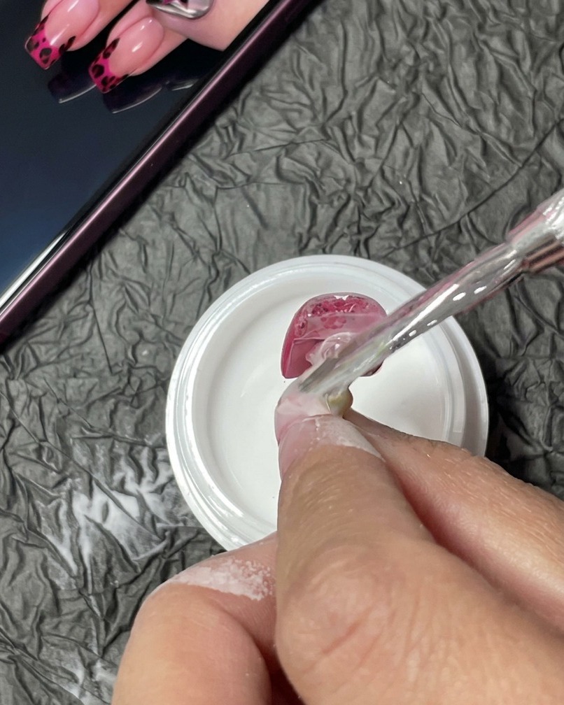 Un ongle situé sous une lampe UV, en train de catalyser.