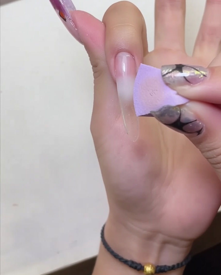 Une main sous une lampe LED pour catalyser la base peel-off appliquée.