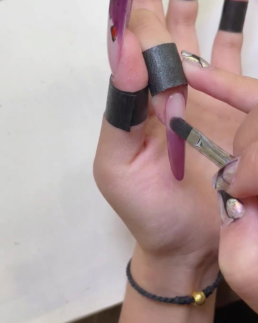 Un pinceau propre utilisé pour lisser les bords de la french manucure cat-eye.