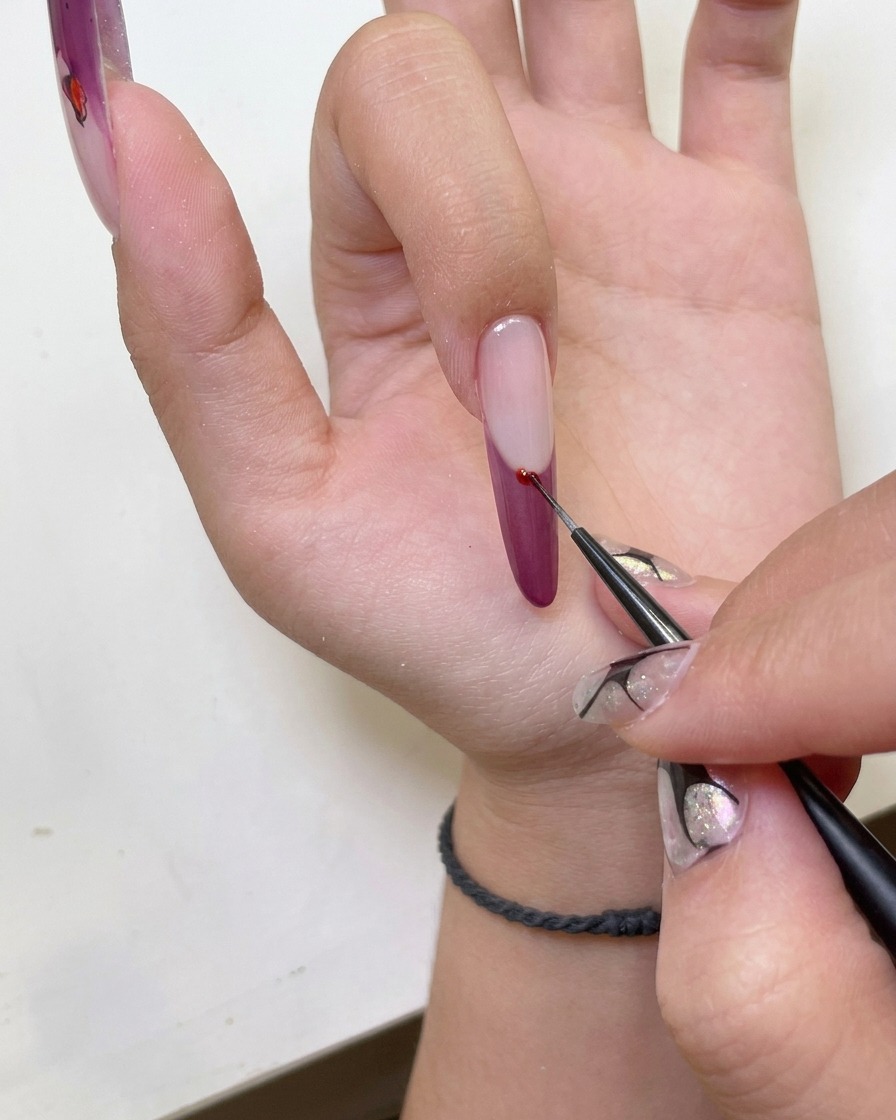 Une main sous une lampe UV pour catalyser le design de la french manucure.