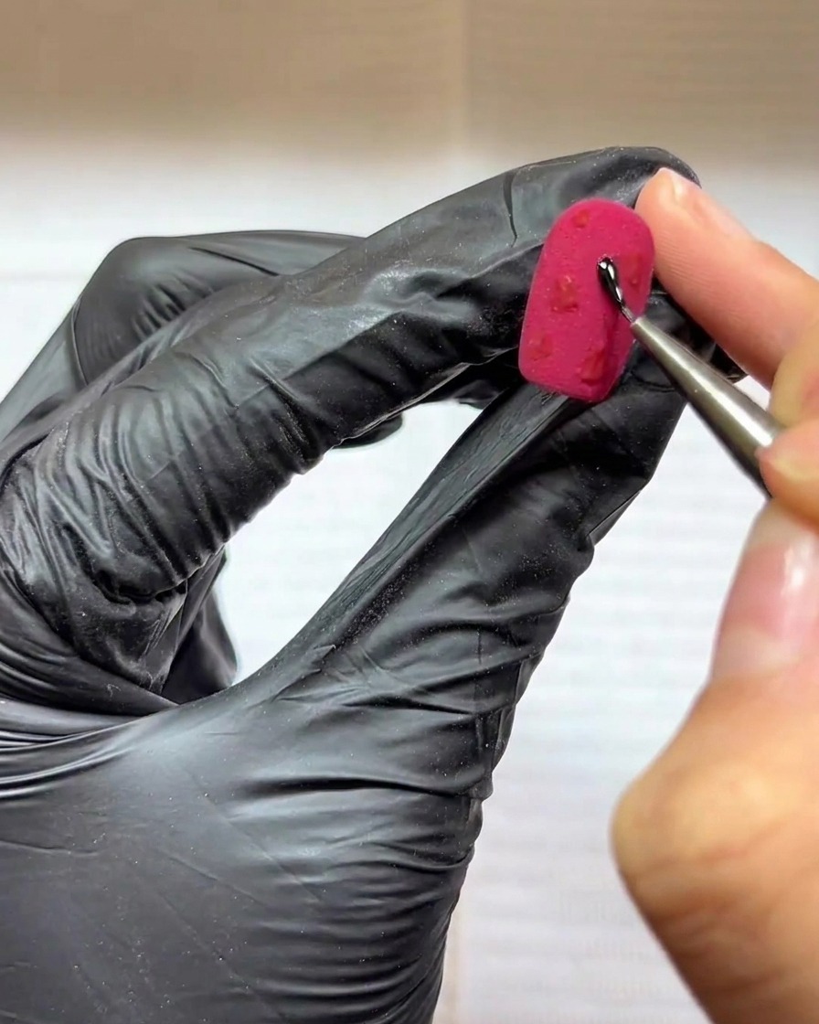 Gros plan dun pinceau souple balayant lexcédent de poudre dun design léopard rouge texturé.