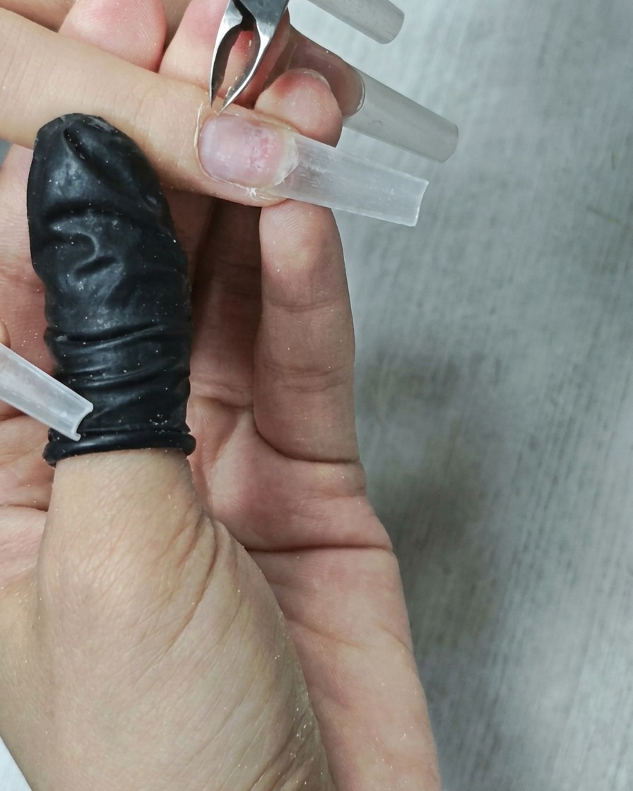 Gros plan dun embout flamme nettoyant le contour de longle.