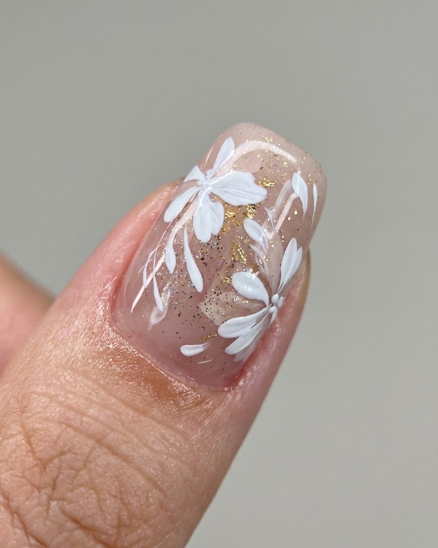 Un pinceau applique une bande diagonale de vernis gel blanc laiteux sur longle.