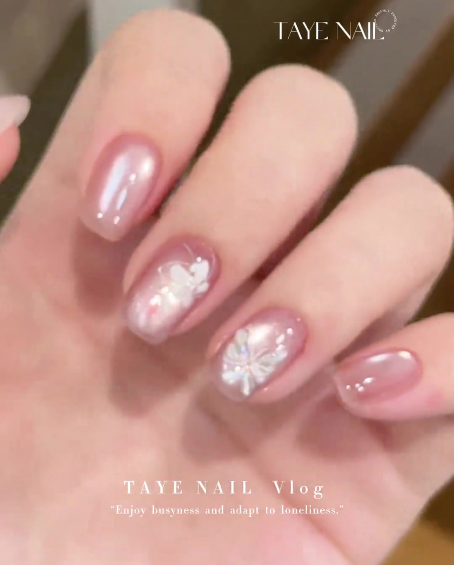 Un pinceau plat appliquant une fine couche de gel cat-eye E225 sur un ongle naturel préparé.