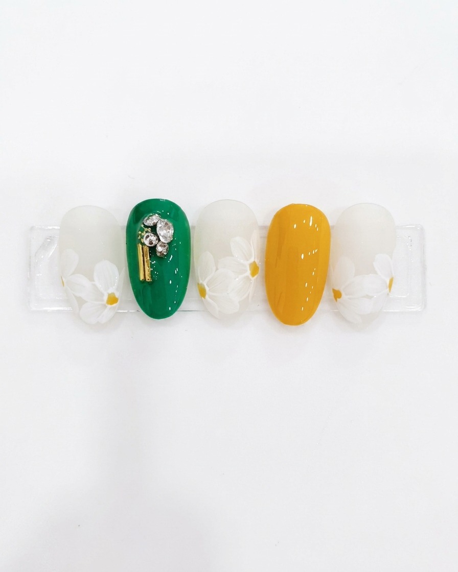 Un pinceau liner peignant des pétales de fleur blancs autour dun centre jaune sur une capsule.