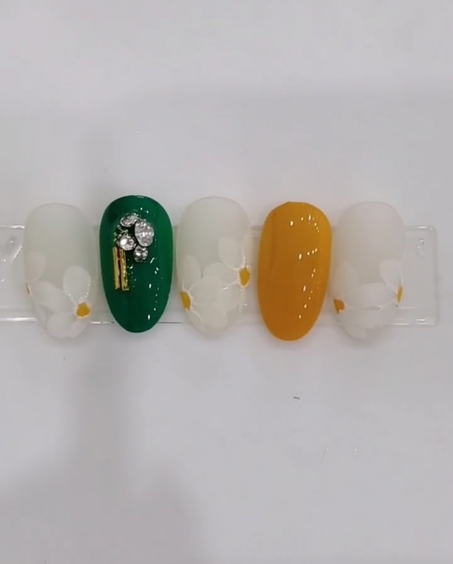Vue rapprochée dun ongle montrant des pétales de marguerite blancs peints en couches superposées sur une base laiteuse.