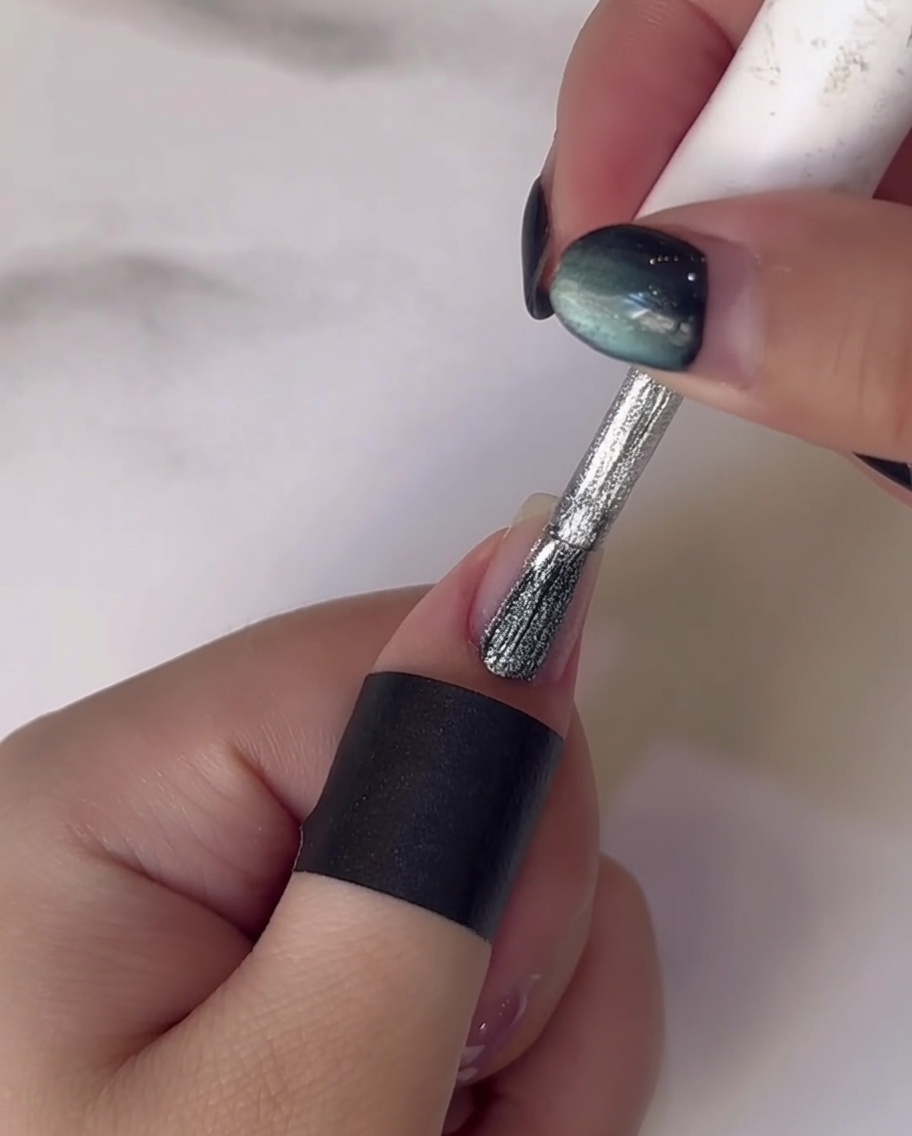 Un outil de dotting appliquant des points de gel blanc pour former des pétales de fleurs sur longle.