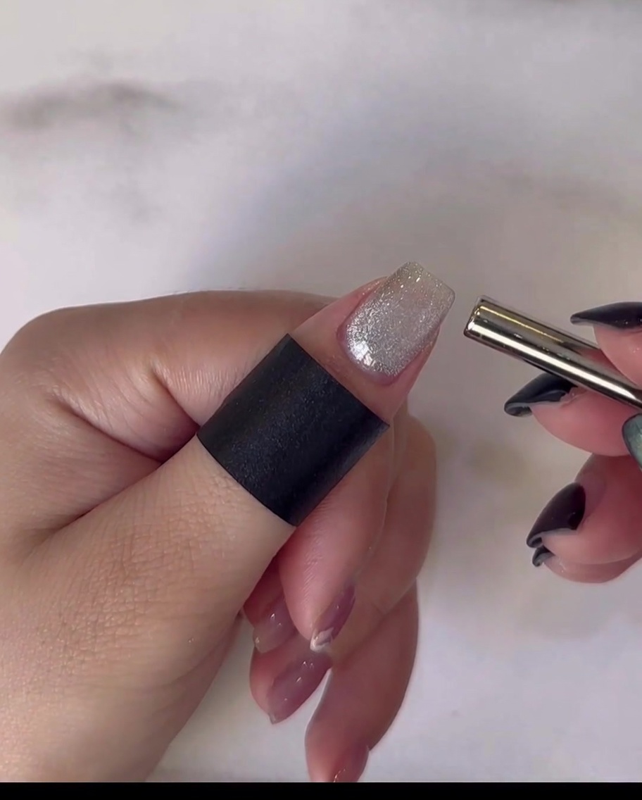 Une main reposant à lintérieur dune lampe UV/LED professionnelle pour catalyser lapplication finale du top coat.