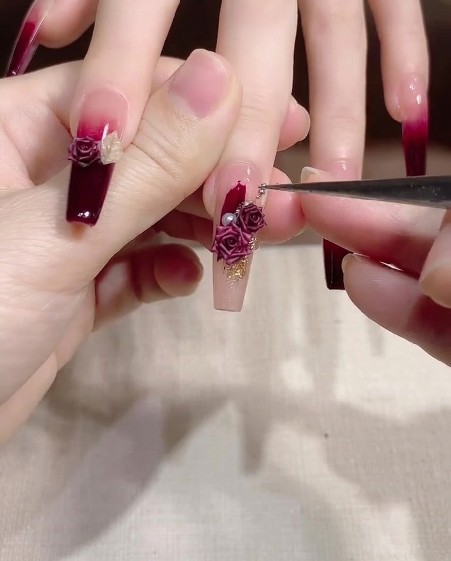 Un pinceau de détail ajustant la position des perles et décorations dorées.