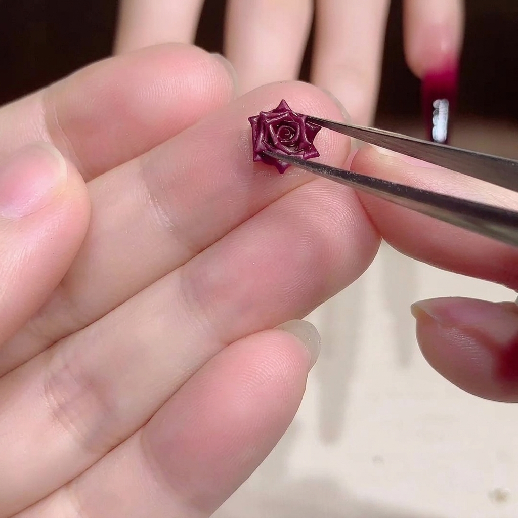 Gros plan sur une pince tenant une petite rose séchée rouge 3D.