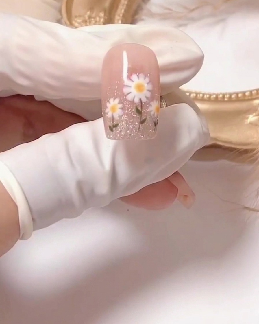 Gros plan dun pinceau appliquant un vernis gel rose diaphane sur un ongle préparé.