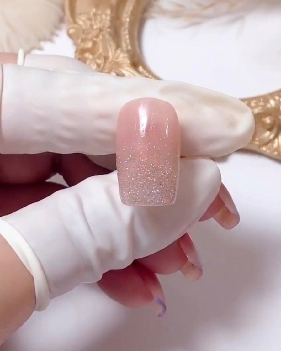 Gros plan dun ongle montrant des lignes de gel blanc tracées en forme de X pour débuter un design de marguerite.
