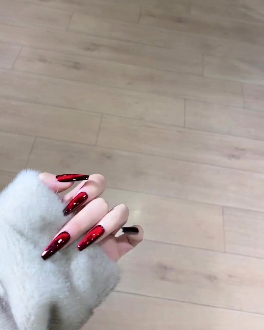 Un pinceau appliquant une couche uniforme de vernis gel noir sur toute la surface dun ongle naturel.