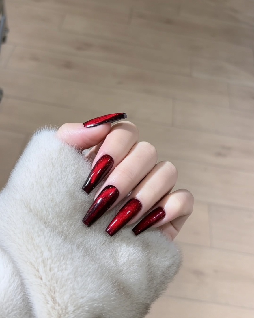 Gros plan sur un ongle recouvert dun vernis gel magnétique rouge scintillant.