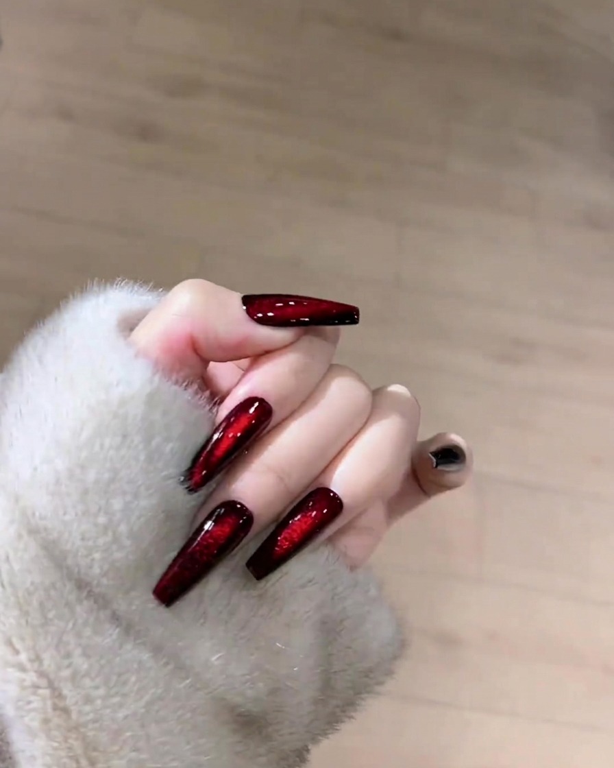 Une main tenant un coton non pelucheux, nettoyant la surface dun ongle rubis œil de chat.