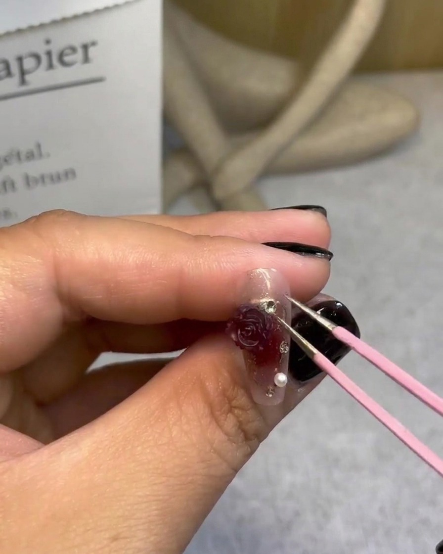 Utilisation dune pince pour ajouter de petites perles autour dune rose 3D.